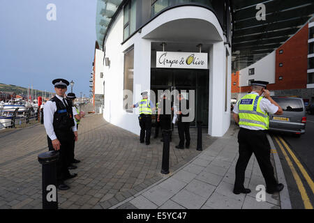 Swansea, Wales, Großbritannien. 8. August 2014. Im Bild: Polizei Aktivität am Eingang der Traube und Restaurant Olive in den Meridian Quay, Swansea, Südwales. Freitag, 8. August 2014 Re: South Wales Police kann bestätigen, dass eine Geiselnahme in der achtundzwanzigsten Etage des Turmes Meridian in Swansea Marina hat endete friedlich ohne ernsthafte Verletzungen. Offiziere hießen die Gebäude am 16:00 am Freitag, 8. August, nachdem ein Mann als Geisel in einem öffentlichen Bereich des Gebäudes, von einem anderen Mann genommen wurde, der im Besitz einer Feuerwaffe war. Bildnachweis: D Legakis/Alamy Live-Nachrichten Stockfoto