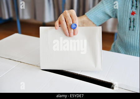 Nahaufnahme von Frauenhand setzen ihre Stimme in die Wahlurne Stockfoto