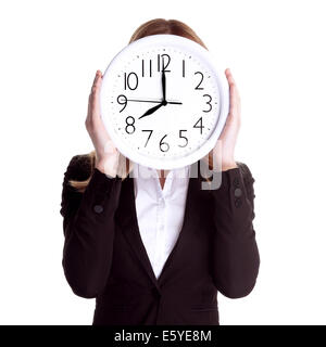 Business-Frau trägt formellen Anzug und hält große Uhr auf Gesicht, isoliert auf weißem Hintergrund, pünktliche Arbeiter Konzept Stockfoto