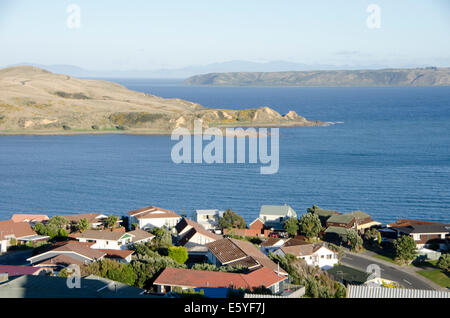 Vorstadtgehäuse auf Klippe top, mit Blick auf Meer, Beginn Landzunge und Mana Island, Camborne, Wellington, Neuseeland Stockfoto