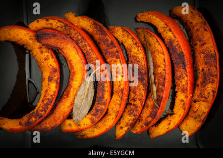 Nahaufnahme von gebratene und gewürzte Kürbis Scheiben auf schwarze Platte von oben Stockfoto