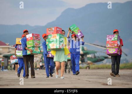 Ludian, der chinesischen Provinz Yunnan. 5. August 2014. Freiwillige vermitteln Hilfsgüter zu Hubschraubern auf einem Flughafen Zhaotong Stadt, Südwest-China Yunnan Provinz, 5. August 2014. Das 6,5-Erdbeben, das Yunnan Ludian County am Sonntag geschlagen hat 617 Todesfälle verursacht. © Xue Sohee/Xinhua/Alamy Live-Nachrichten Stockfoto