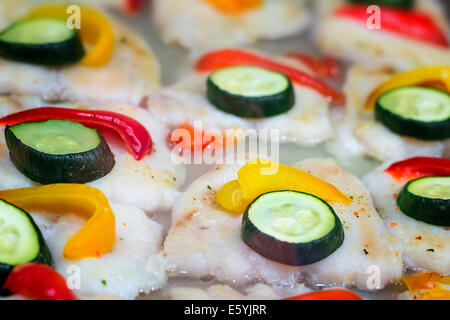 Appetitliche Portionen von gebratenem Fisch und Gemüse: Gurken und Paprika. Stockfoto