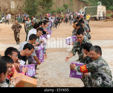 Ludian, der chinesischen Provinz Yunnan. 5. August 2014. Menschen vermitteln Relief Materialien aus Hubschrauber in Erdbeben betroffenen Longtoushan Stadt Ludian County, der südwestlichen chinesischen Provinz Yunnan, 5. August 2014 entladen. © Tao Liang/Xinhua/Alamy Live-Nachrichten Stockfoto