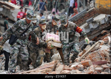 Ludian, der chinesischen Provinz Yunnan. 5. August 2014. Rettungskräfte tragen den Körper des Opfers in Erdbeben betroffenen Longtoushan Stadt Ludian County, der südwestlichen chinesischen Provinz Yunnan, 5. August 2014. © Tao Liang/Xinhua/Alamy Live-Nachrichten Stockfoto