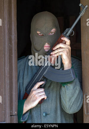 Mann mit einem Maschinengewehr Stand in der Tür Stockfoto