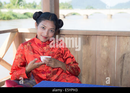 Asiatische Frau trinken aus einer Tasse Stockfoto