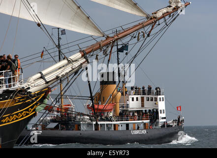 Rostock-Warnemünde, Deutschland. 9. August 2014. Clipper Stad Amsterdam (L) und Dampf-Eisbrecher Stettin Segeln auf der Ostsee während der maritime Festival Hanse Sail aus Rostock-Warnemünde, Deutschland, 9. August 2014. Mehr als 200 Schiffe beteiligen sich die Hanse Sail, die Hunderte von Tausenden von Besuchern anlocken soll. Foto: BERND WUESTNECK/DPA/Alamy Live-Nachrichten Stockfoto