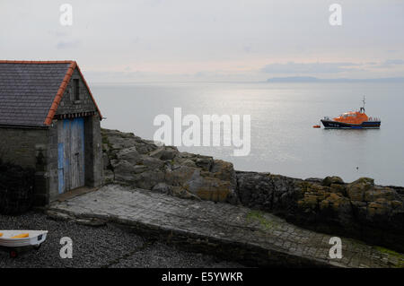 Ein RNLI-Rettungsboot hinter dem alten Rettungsboot-Haus in Moelfre auf Anglesey in den frühen Morgenstunden. Stockfoto