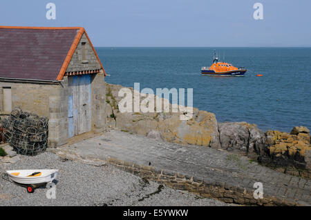 Ein RNLI-Rettungsboot hinter dem alten Rettungsboot-Haus in Moelfre auf Anglesey Stockfoto