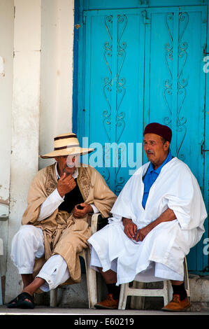 Afrika, Nordafrika, Maghreb, Süd Tunesien, Governorat von Tataouine. Tataouine. Alte Männer diskutieren sitzen direkt vor der Haustür. Stockfoto