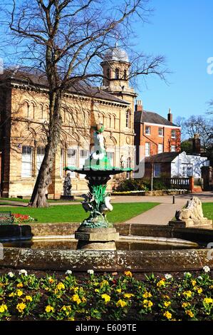 Kanzler des Gesetzes Brunnen im Beacon Park mit dem alten Bibliotheksgebäude nach hinten, Lichfield, Staffordshire, England, UK. Stockfoto