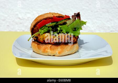 Vegetarische Kichererbsen, Mais und Karotten-Burger mit Salat in einem Sesam Brötchen, UK. Stockfoto