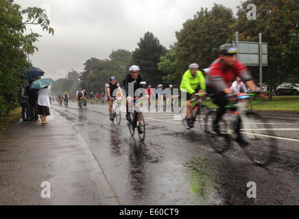 West Molesey, Surrey, UK. 10. August 2014. Radfahrer im Prudential Fahrt London Gesicht sintflutartigen Regen, als Durchgang durch West Molesey Surrey. Bildnachweis: Cephas Picture Library/Alamy Live-Nachrichten Stockfoto