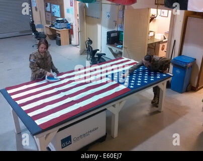 US-Armeesoldaten mit dem 111. Quartiermeister Unternehmen Eisen und untersuchen eine Flagge in einer Zeremonie zu Ehren 2. Juli 2014 Bagram Airfield in Parwan Provinz, Afghanistan verwendet werden. Stockfoto