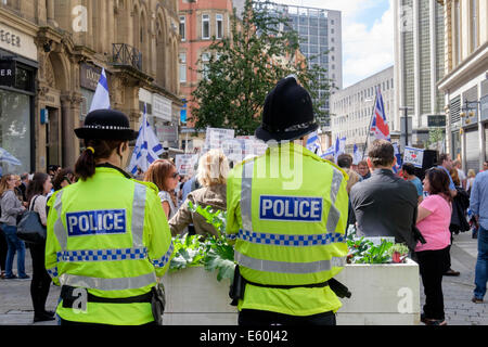 Manchester, England, Vereinigtes Königreich, 9. August 2014. Zwei Polizisten beobachten, die pro-israelischen und Antisemitismus Demonstranten in King Street außerhalb einer jüdischen Besitz Beauty-Shop israelische Produkte verkaufen und fürchtete um ein Ziel für den Marsch propalästinensische Demonstration gegen die israelische Besatzung des Gazastreifens zu sein. Stockfoto