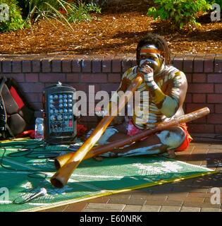 Ein Aborigine Mann spielt Didgeridoo für Touristen in Circular Quay, Sydney, Australien Stockfoto