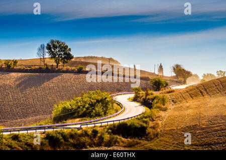 Kurvenreiche Straße und Hügel an einem Sommertag in Crete Senesi in Toskana, Italien Stockfoto