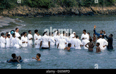 Religiöse Teilnehmer gekleidet in weißen Line-up für Full-Immersion-Taufe im Wasser aus Martinique, eine Insel in der Karibik. Stockfoto