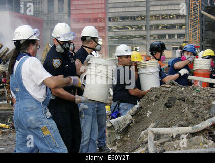 Rettungskräfte Mann eine Bucket Brigade um Schutt aus den Trümmern des World Trade Centers in der Nachmahd von einem massiven Terroranschlag entfernen, die die Twin Towers 2.606 Tötungleute 20. September 2001 in New York, New York zerstört. Stockfoto