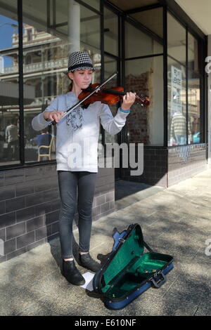 Ein junges Mädchen ist mit ihrer Violine in Fremantle, Western Australia als Straßenmusikant. Stockfoto