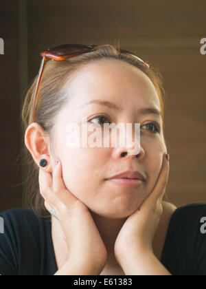 Neugierige junge asiatische Frau auf etwas in der Natur Stockfoto