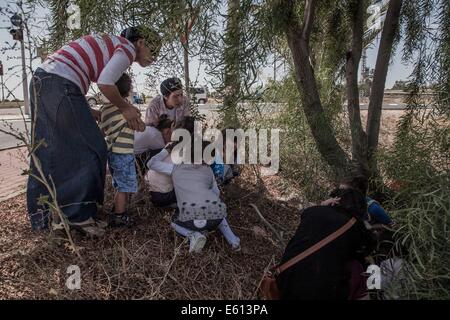 Gaza-Grenze, Israel grenzt an den Gaza-Streifen. 10. August 2014. Israelis nehmen Abdeckung an der Seite der Straße als Warnung Sirenen für ankommenden Raketen Ton in der Nähe von israelische Stadt Sderot, südlichen Israel grenzt an den Gaza-Streifen am 10. August 2014. Israelische Beamte der ägyptischen Vorschlag zur Durchführung einer anderen 72 Stunden Waffenruhe ab Montag um 01:00 Ortszeit (GMT-2200) angenommen, sagte ein israelischen Beamten Xinhua. © JINI/Albert Sadikov/Xinhua/Alamy Live-Nachrichten Stockfoto