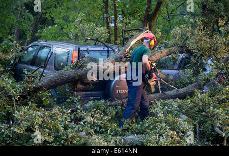 Bad Schwalbach, Deutschland. 10. August 2014. Ein Feuerwehrmann versucht, zerstörten Autos in Bad Schwalbach, Deutschland, 10. August 2014. Ein Tornado gemeinsam mit einer regen Sturm verursachte Schäden in Millionenhöhe in den Kurort. Zahlreiche Autos wurden beschädigt, Dächer der Häuser abgenommen und Waldflächen zerstört. Foto: Boris Roessler/Dpa/Alamy Live News Stockfoto