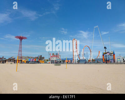 Der Fallschirm springen (L) und anderen Festplatz Fahrten stehen an der Strandpromenade von Brighton Beach auf Coney Island, New York, USA, 24. Juni 2014. Der Parachute Jump ist ein 80 Meter hohen roten Stahlturm mit einem Gewicht von 150 Tonnen. Ursprünglich es war Teil der New York World Ausstellung 1939 im Flushing Meadows Park und wurde von den Betreibern der Steeplechase Park wo es bis 1968 diente hier gebracht. Seit Juli 1977 der Turm ist eines der Wahrzeichen der Stadt und ist seit 1989 unter Denkmalschutz. Foto: Alexandra Schuler - Achtung! KEIN KABEL-SERVICE- Stockfoto