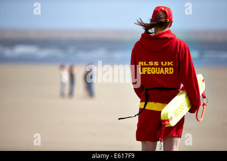 Ein Bademeister RLSS oder Royal Life Saving steht Uhr unweit vom Meer an einem Strand. Leben Wachen Hilfe im Wasser ertrinken zu verhindern. Stockfoto