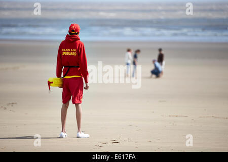 Ein Bademeister RLSS oder Royal Life Saving steht Uhr unweit vom Meer an einem Strand. Leben Wachen Hilfe im Wasser ertrinken zu verhindern. Stockfoto