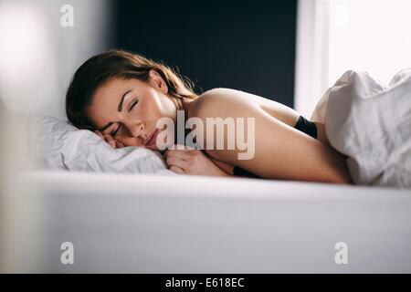 Porträt des entspannten junge Dame in ihrem Bett schlafen. Weibliches Modell friedlich schlafend in ihrem Bett. Stockfoto