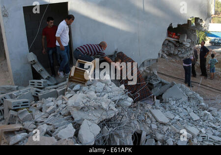 Nablus, Nablus. 11. August 2014. Palästinenser inspizieren den Schaden des Hauses von Zakaria al-Aqra, nachdem er von der israelischen Armee in der West Bank Qabalan, in der Nähe von Nablus, 11. August 2014 getötet wurde. Eine israelische Kraft überfiel Stadt Nablus um Zakaria al-Aqra, 24, aus Fatah-Bewegung, zu verhaften, aber kollidierte er mit ihnen, bevor er bei seiner Familie zu Hause, sagte der palästinensischen Sicherheitskräfte getötet wurde. Fünf der al-Aqra Familie wurde verletzt, während Teil des Hauses wurden von israelischen Truppen zerstört. Bildnachweis: Ayman Nobani/Xinhua/Alamy Live-Nachrichten Stockfoto