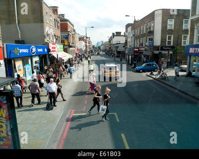 Anzeigen von Kingsland Road High Street & Polizei Auto in Richtung Central London & junge Frauen überschreiten Straße in Dalston London UK KATHY DEWITT Stockfoto