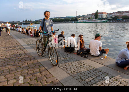 Prag Naplavka, junge Menschen am Wasser, Radfahrer, Prager Fahrrad Tschechische Republik Tschechien Mann mit einem Fahrradmann, der Fahrrad schiebt Stockfoto