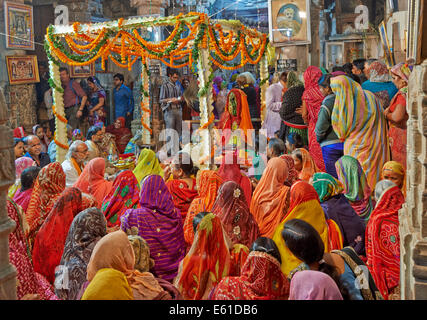 Hindi Inderinnen mit bunten Kleidern während der Zeremonie innen Jagdish Tempel, Udaipur, Rajasthan, Indien Stockfoto