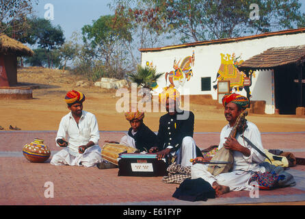 Muslimische Künstler spielen traditionelle Musik und Gesang. Im Hintergrund, Haus mit traditionellen Gemälden (Indien) Stockfoto