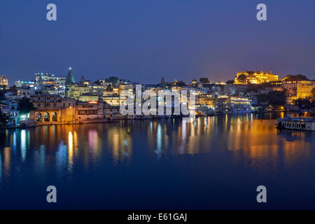 Blick auf die Stadt in der Nacht von Udaipur mit Pichola-See und Ghat vor, Spiegelung im Wasser, Rajasthan, Indien Stockfoto