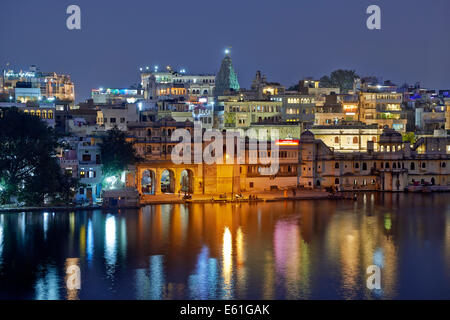 Blick auf die Stadt in der Nacht von Udaipur mit Pichola-See und Ghat vor, Spiegelung im Wasser, Rajasthan, Indien Stockfoto