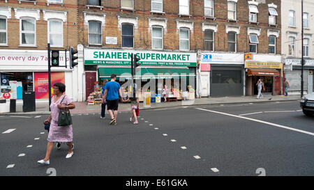 Menschen Sie Kreuzung Stoke Newington High Street N16 an der Ampel von KATHY DEWITT Shaheen Supermarkt Dalston London, UK Stockfoto