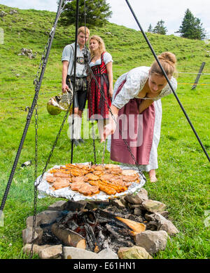 Bad Feilnbach, Deutschland 10. Juli 2014. Touristen und einheimische feiern ein Barbecue in traditioneller Kleidung Lederhose und Dirndl mit bayerischer Musik Braffband auf Huber Mountainhut, Farrenpoint Berg in Bad Feilnbach Bayern, Deutschland, Europa © Peter Schatz/Alamy Stockfoto