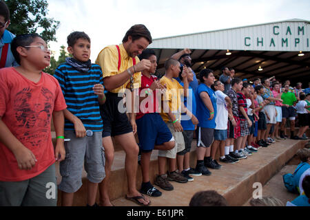 Teen Boys und Ratgeber zu tanzen, während des Singens bei täglichen Kundgebung am Camp Champions, ein Schlaf-über Sommer-Camp am See LBJ in zentralen TX Stockfoto