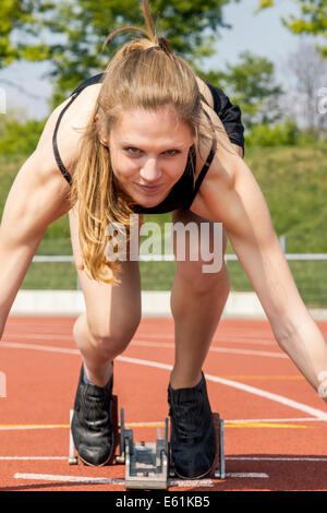 Sportlerin im Start Position Lächeln für die Kamera Stockfoto