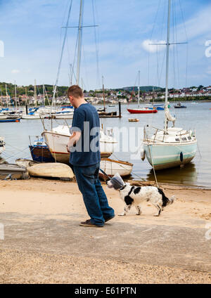 Mann zu Fuß Hund tragen E-Halsband oder elisabethanischen Kragen am Meer Stockfoto