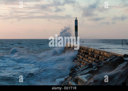 Aberystwyth, Wales, UK. 11. August 2014. Gepeitscht bis durch den Sturm namens Bertha Meer stürzt Wellen gegen den Leuchtturm in Aberystwyth bei Sonnenuntergang. Bildnachweis: Jon Freeman/Alamy Live-Nachrichten Stockfoto