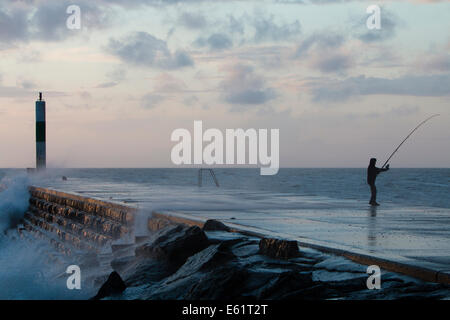 Aberystwyth, Wales, UK. 11. August 2014. Gepeitscht bis durch den Sturm namens Bertha Meer stürzt Wellen gegen den Leuchtturm in Aberystwyth bei Sonnenuntergang. Bildnachweis: Jon Freeman/Alamy Live-Nachrichten Stockfoto