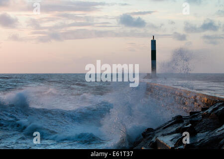 Aberystwyth, Wales, UK. 11. August 2014. Gepeitscht bis durch den Sturm namens Bertha Meer stürzt Wellen gegen den Leuchtturm in Aberystwyth bei Sonnenuntergang. Bildnachweis: Jon Freeman/Alamy Live-Nachrichten Stockfoto