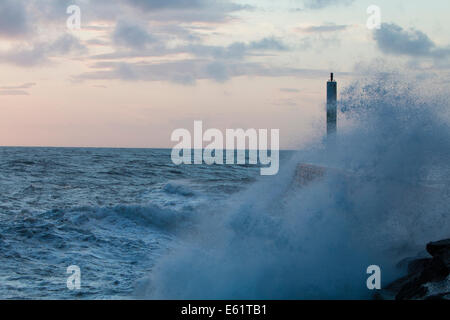 Aberystwyth, Wales, UK. 11. August 2014. Gepeitscht bis durch den Sturm namens Bertha Meer stürzt Wellen gegen den Leuchtturm in Aberystwyth bei Sonnenuntergang. Bildnachweis: Jon Freeman/Alamy Live-Nachrichten Stockfoto