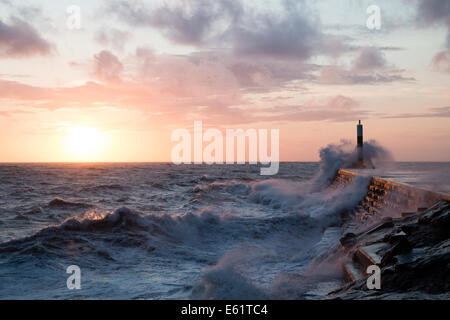 Aberystwyth, Wales, UK. 11. August 2014. Gepeitscht bis durch den Sturm namens Bertha Meer stürzt Wellen gegen den Leuchtturm in Aberystwyth bei Sonnenuntergang. Bildnachweis: Jon Freeman/Alamy Live-Nachrichten Stockfoto