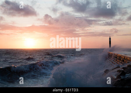 Aberystwyth, Wales, UK. 11. August 2014. Gepeitscht bis durch den Sturm namens Bertha Meer stürzt Wellen gegen den Leuchtturm in Aberystwyth bei Sonnenuntergang. Bildnachweis: Jon Freeman/Alamy Live-Nachrichten Stockfoto